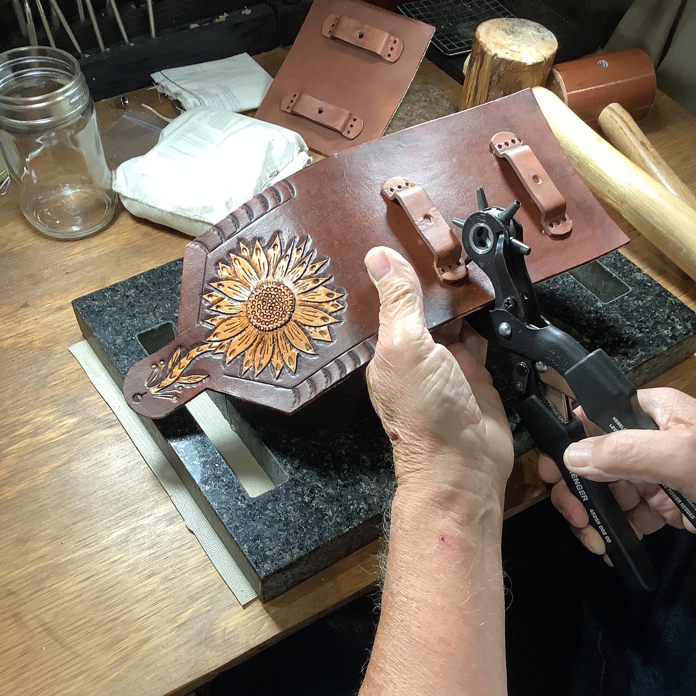 A leather worker make a saddle phone holder.