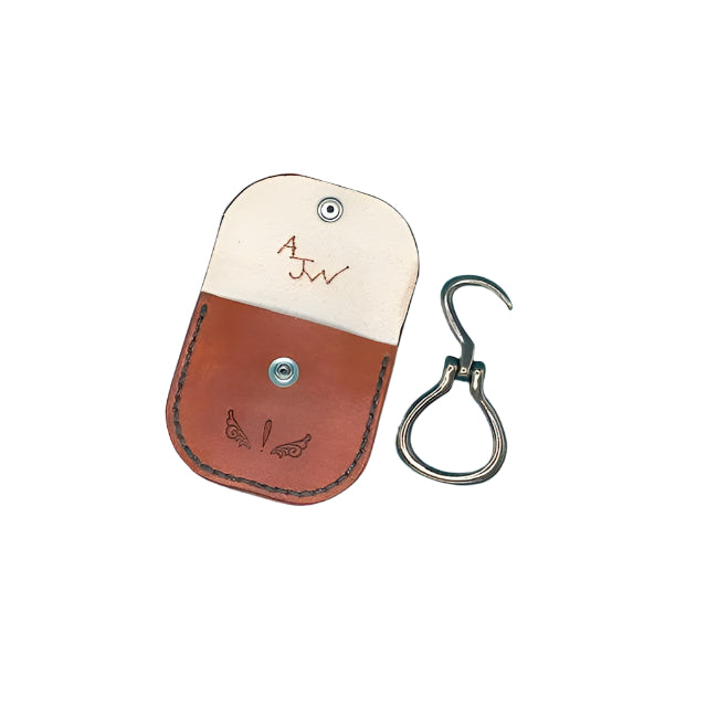 A saddle tan leather folding hoof pick  holder for a saddle billet with a folding hoof pick.