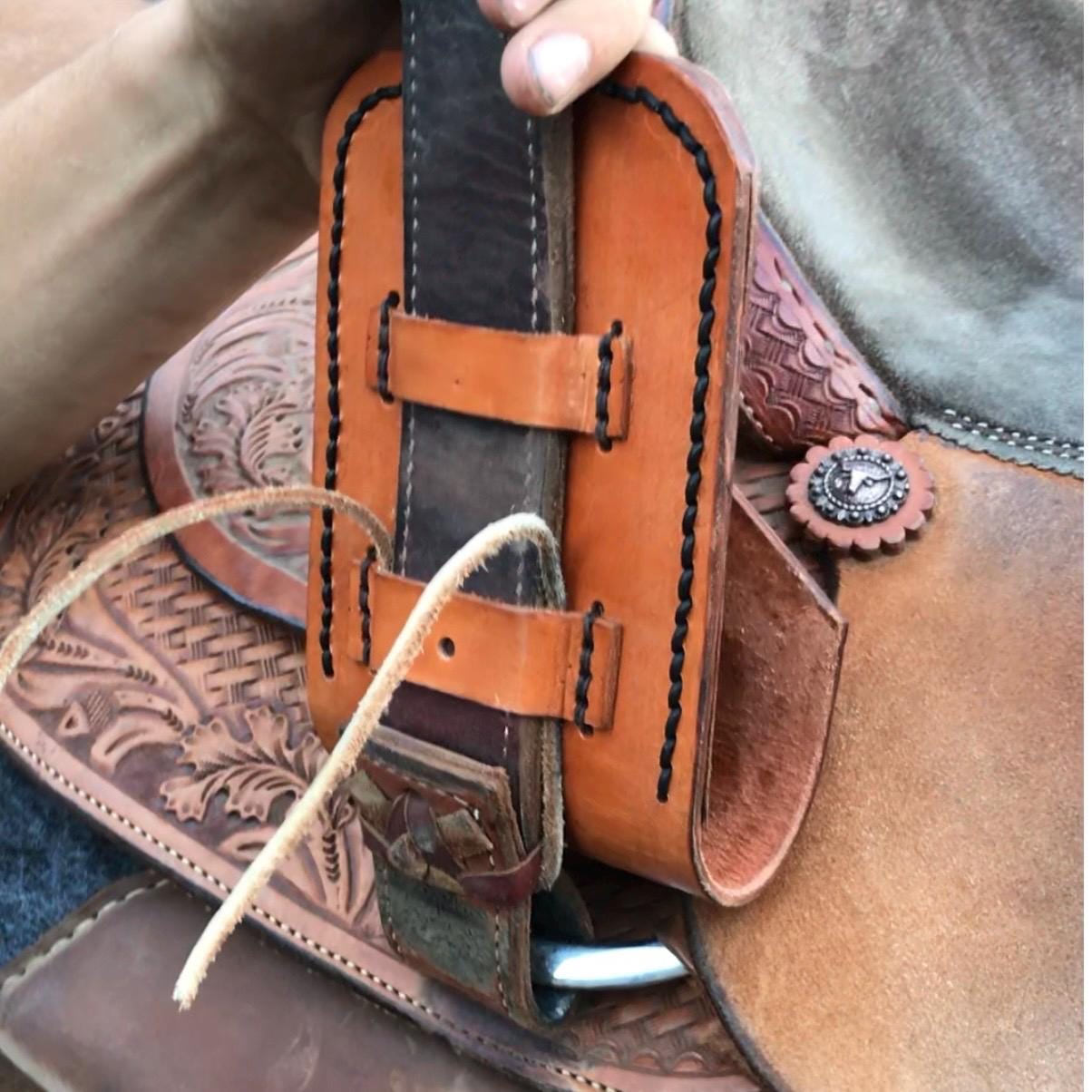 A phone holder being attached to a saddle billet.
