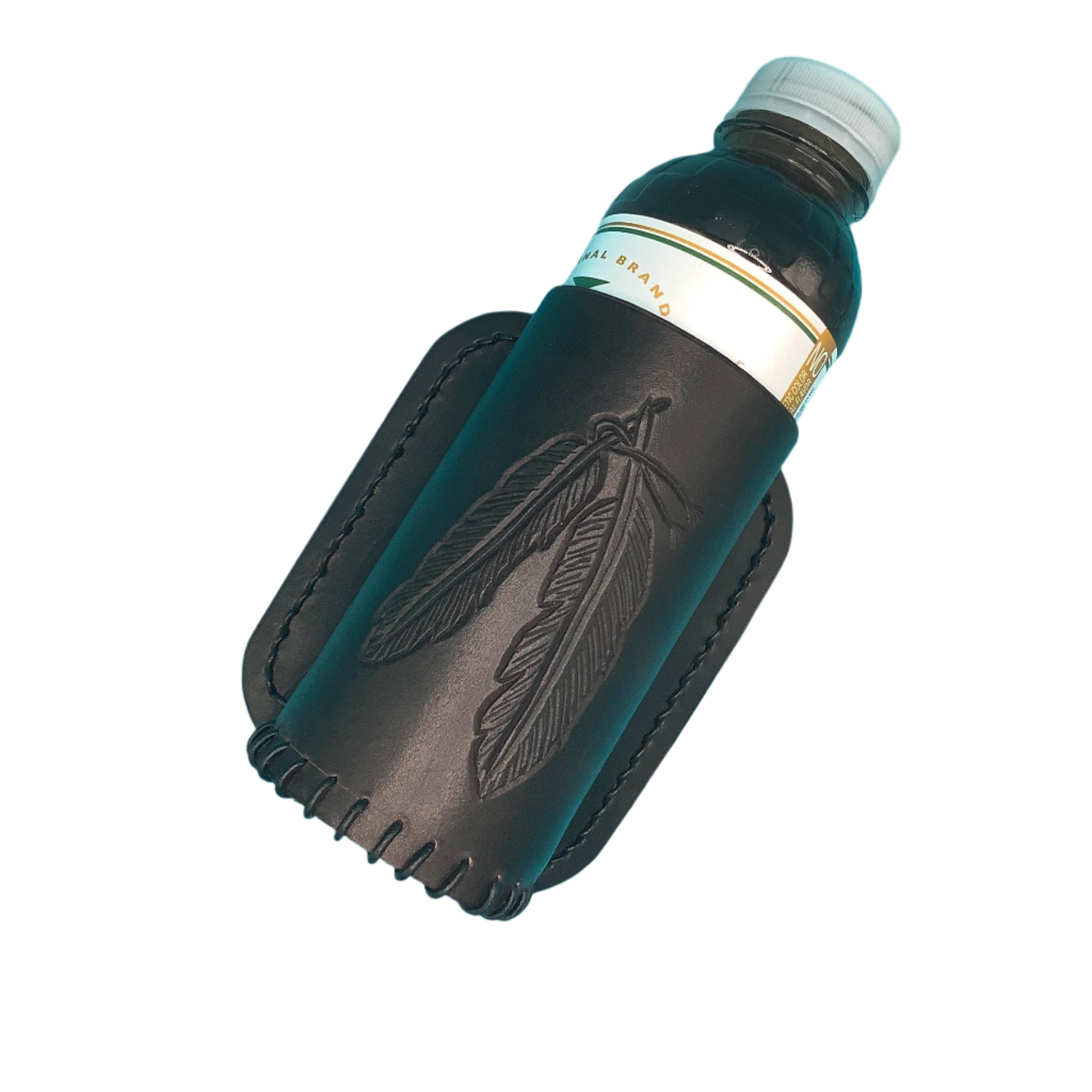 Dark chocolate bottle holder for saddle billet strap with hand tooled feathers with a sweet tea bottle in it.
