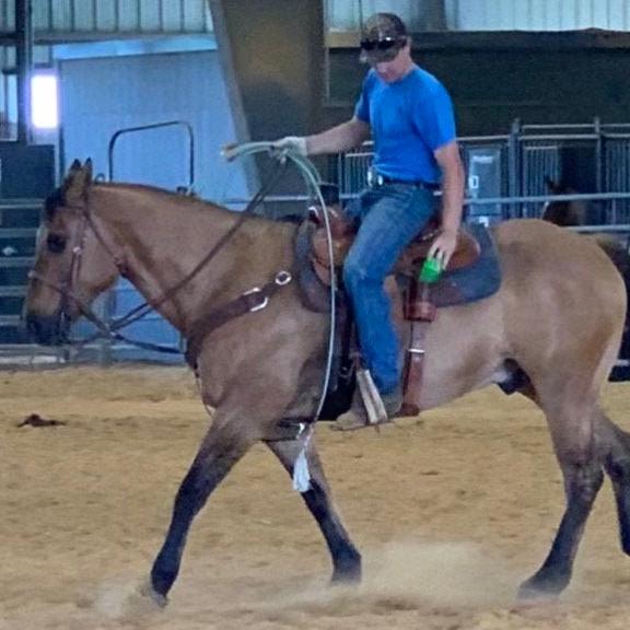 Rider in an arena using a billet strap bottle holder.