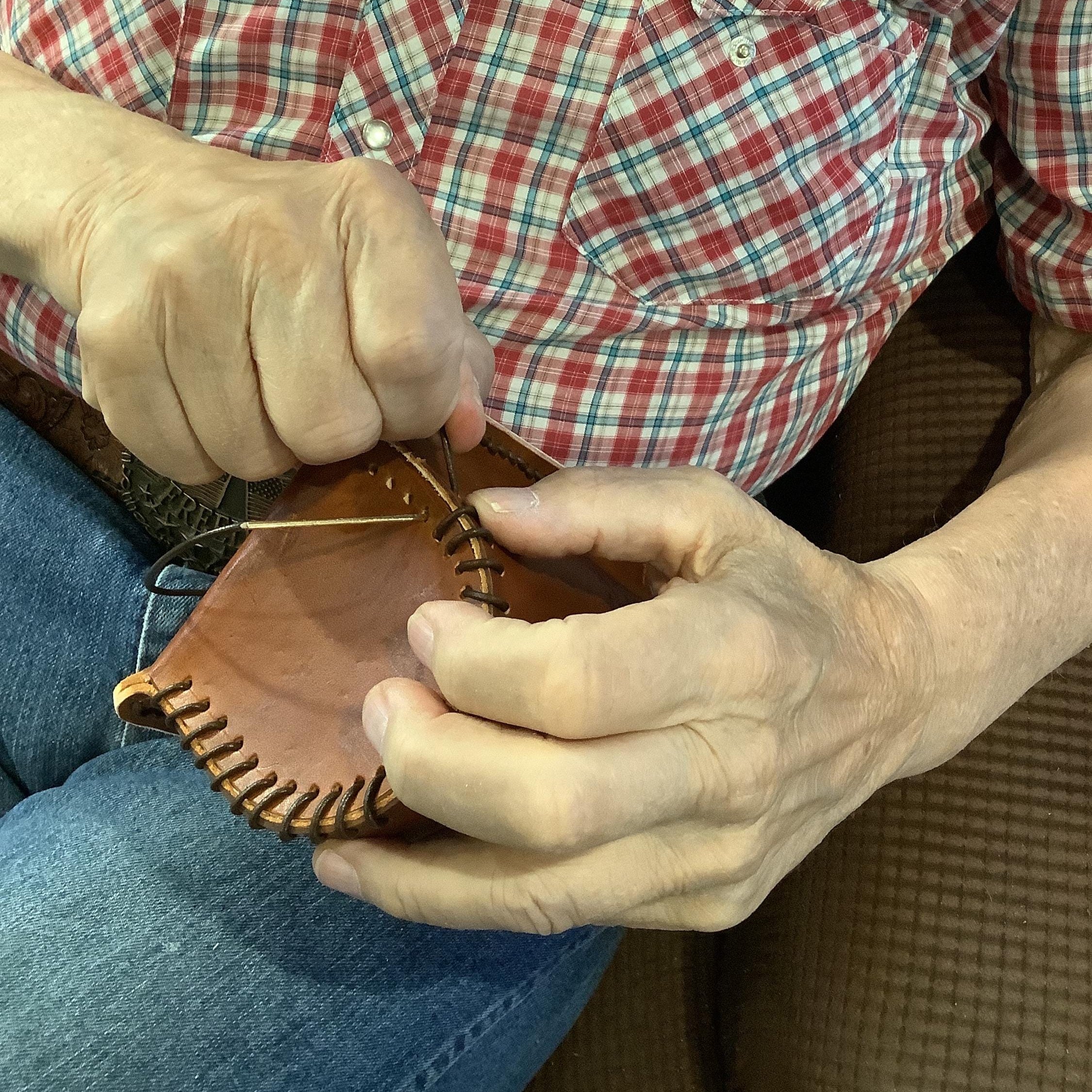Leather worker making a saddle bottle holder.