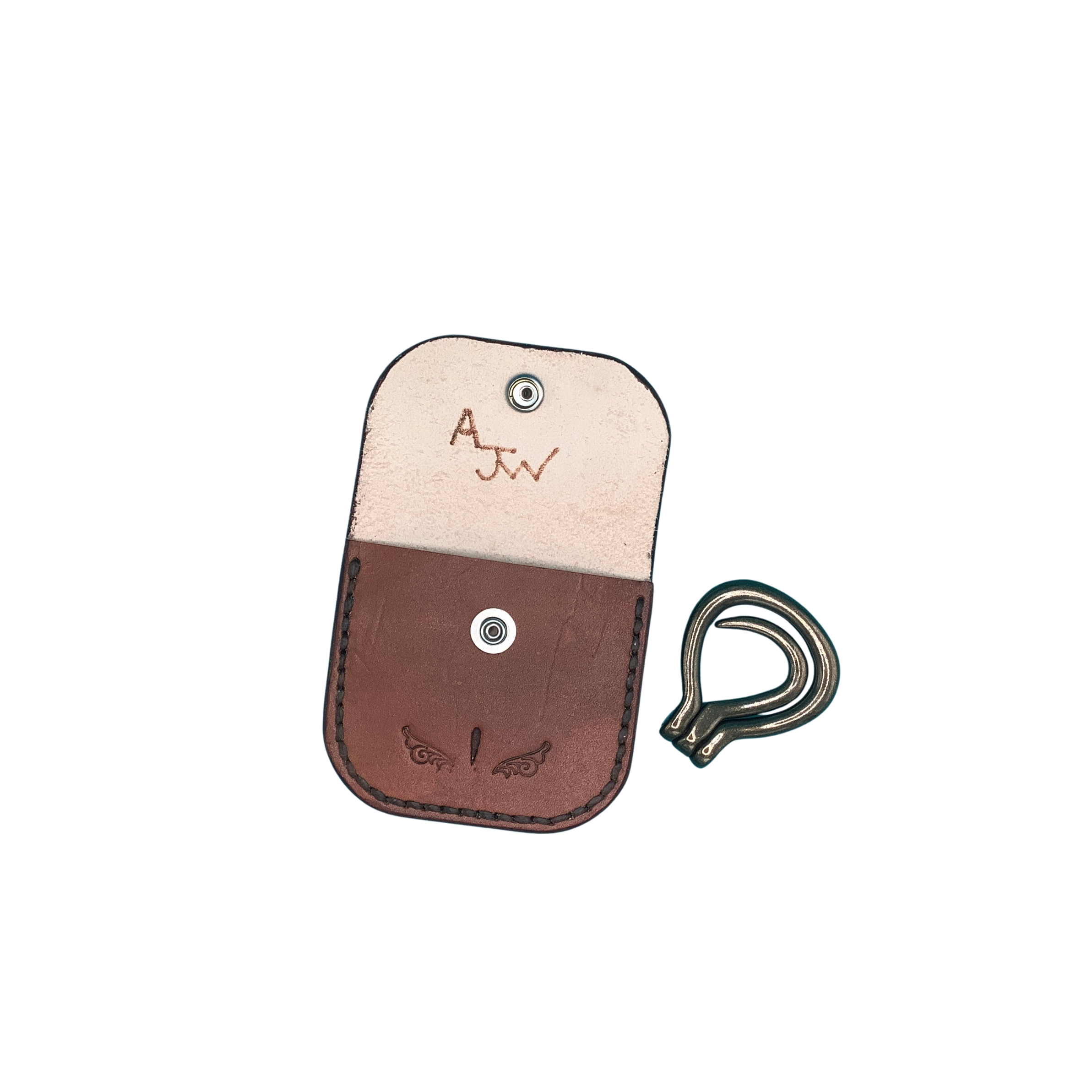 A hand tooled mahogany leather folding hoof pick holder with a brass folding hoof pick.