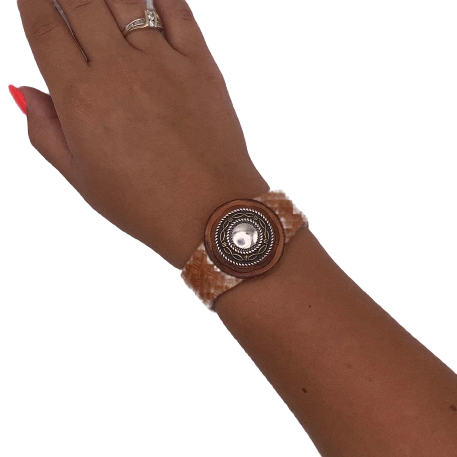 Brown leather bracelet with a decorative concho on a wrist against a white background