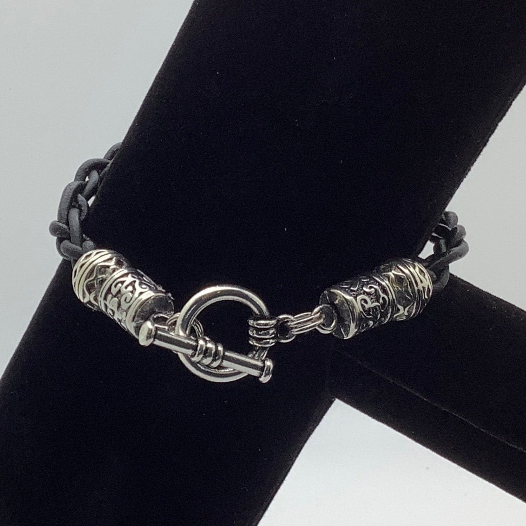 A close up of a black leather braided bracelet. 