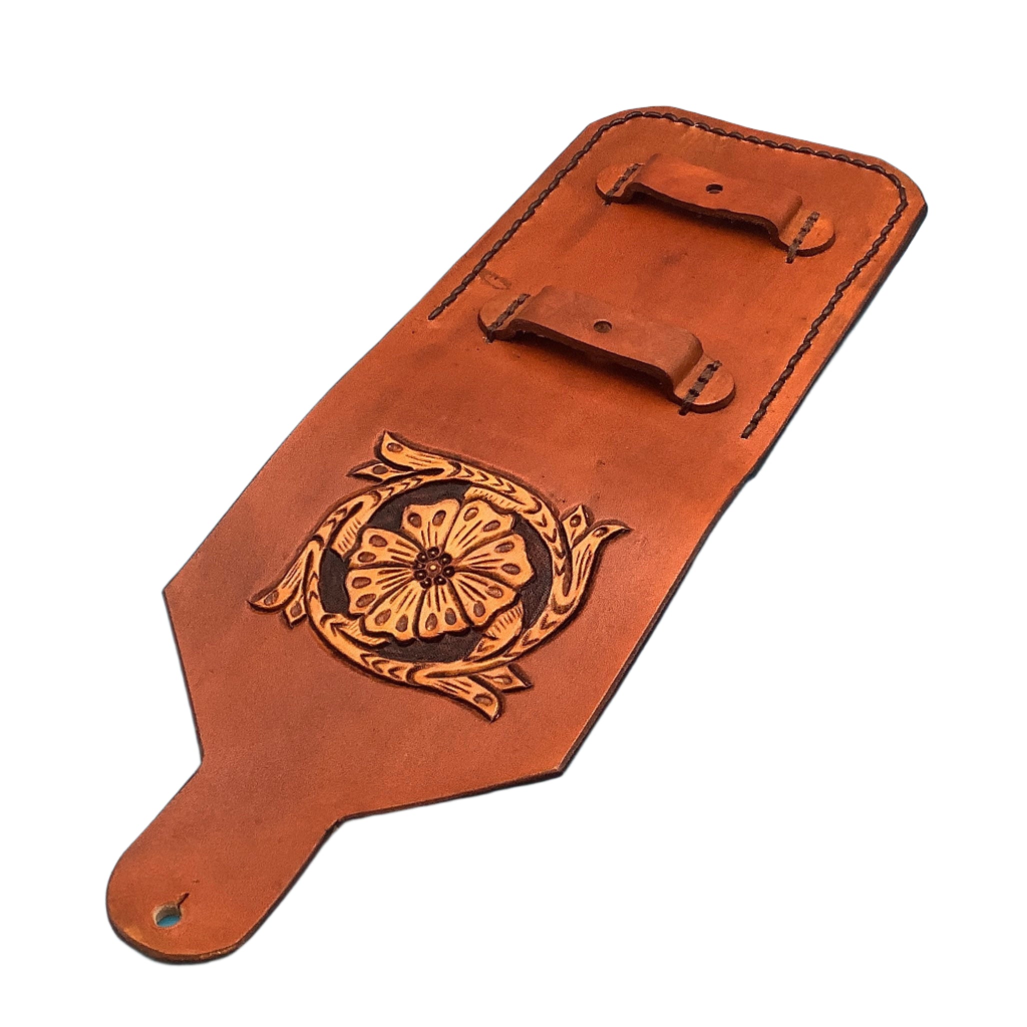 A leather phone holder for saddle billet with hand tooled saddle flower showing the straps that hook to the billet.