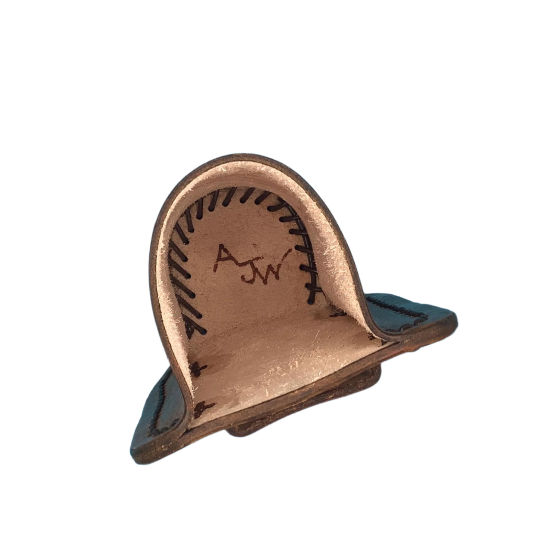 The inside of a tan leather drink holder for saddle billet with hand tooled horseshoes.