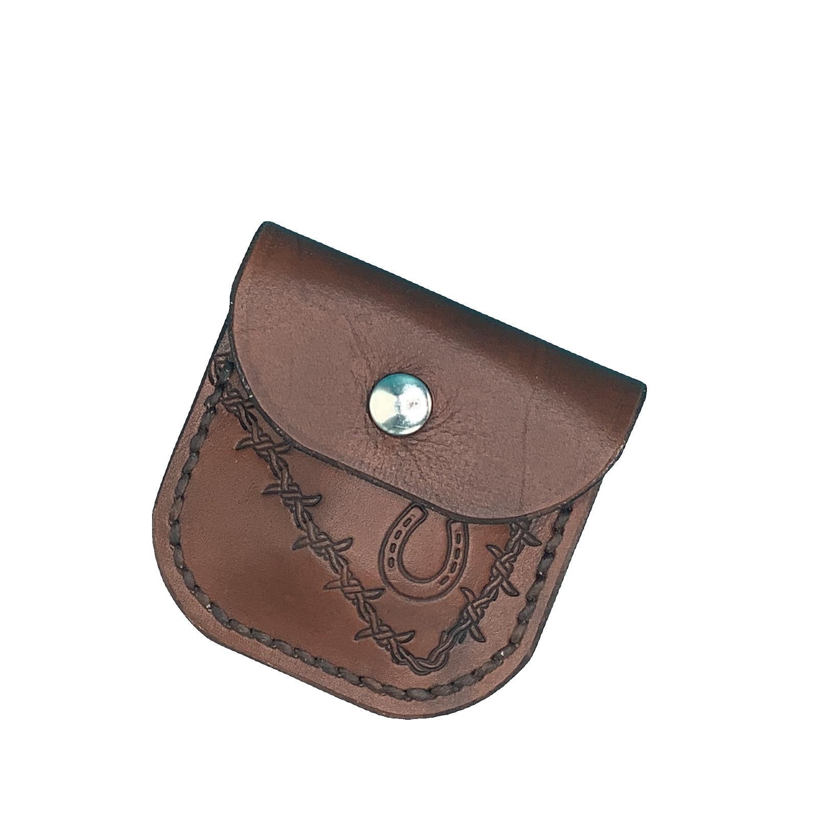 A medium brown folding hoof pick holder for saddle billet with hand tooled horseshoe and barbed wire.