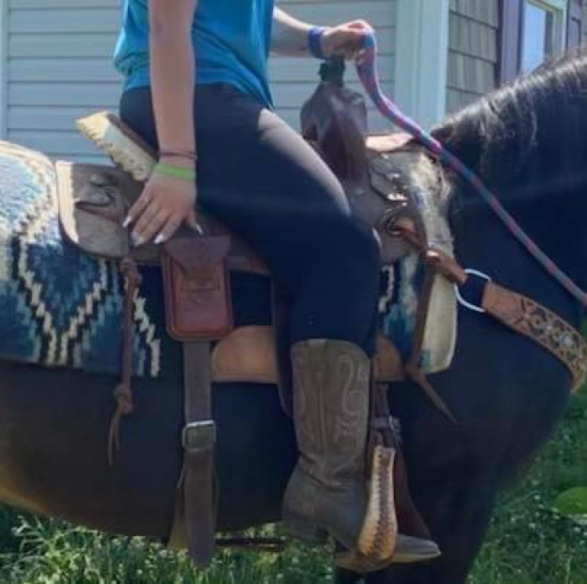 A horseback rider using a rear cinch phone holder.
