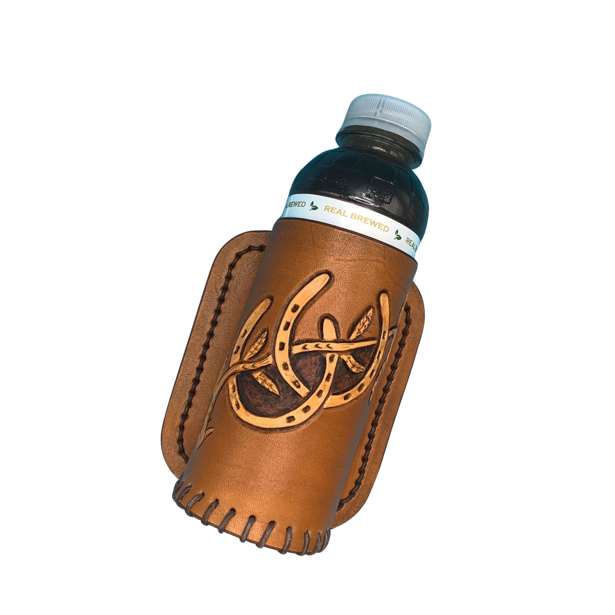 A tan leather drink holder for saddle billet with hand tooled horseshoes.