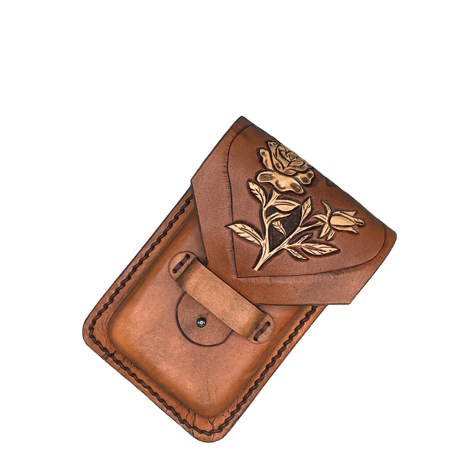 A tan leather saddle phone holder with hand tooled roses inside a heart.