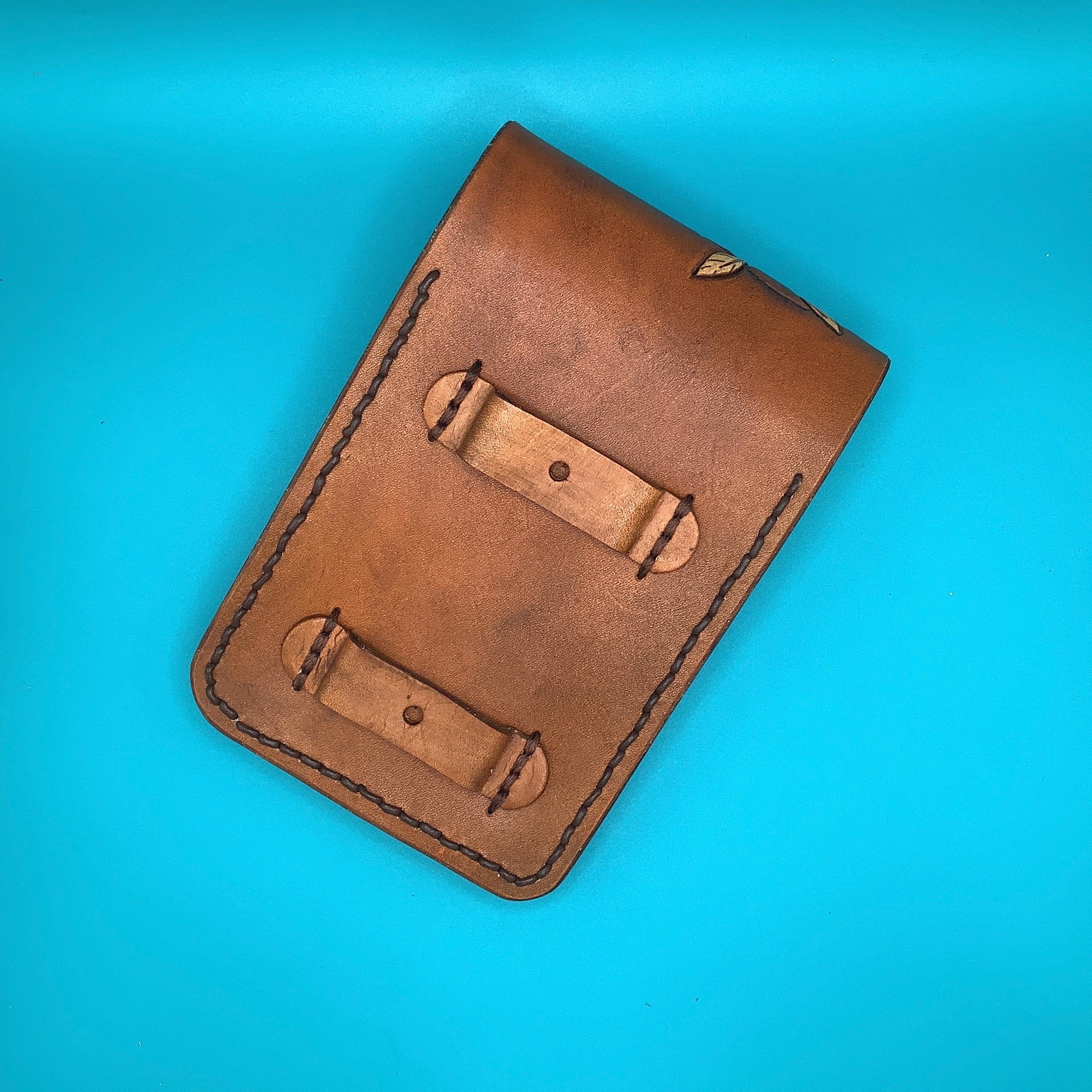 A back view of a leather phone holder that attaches to a saddle billet.