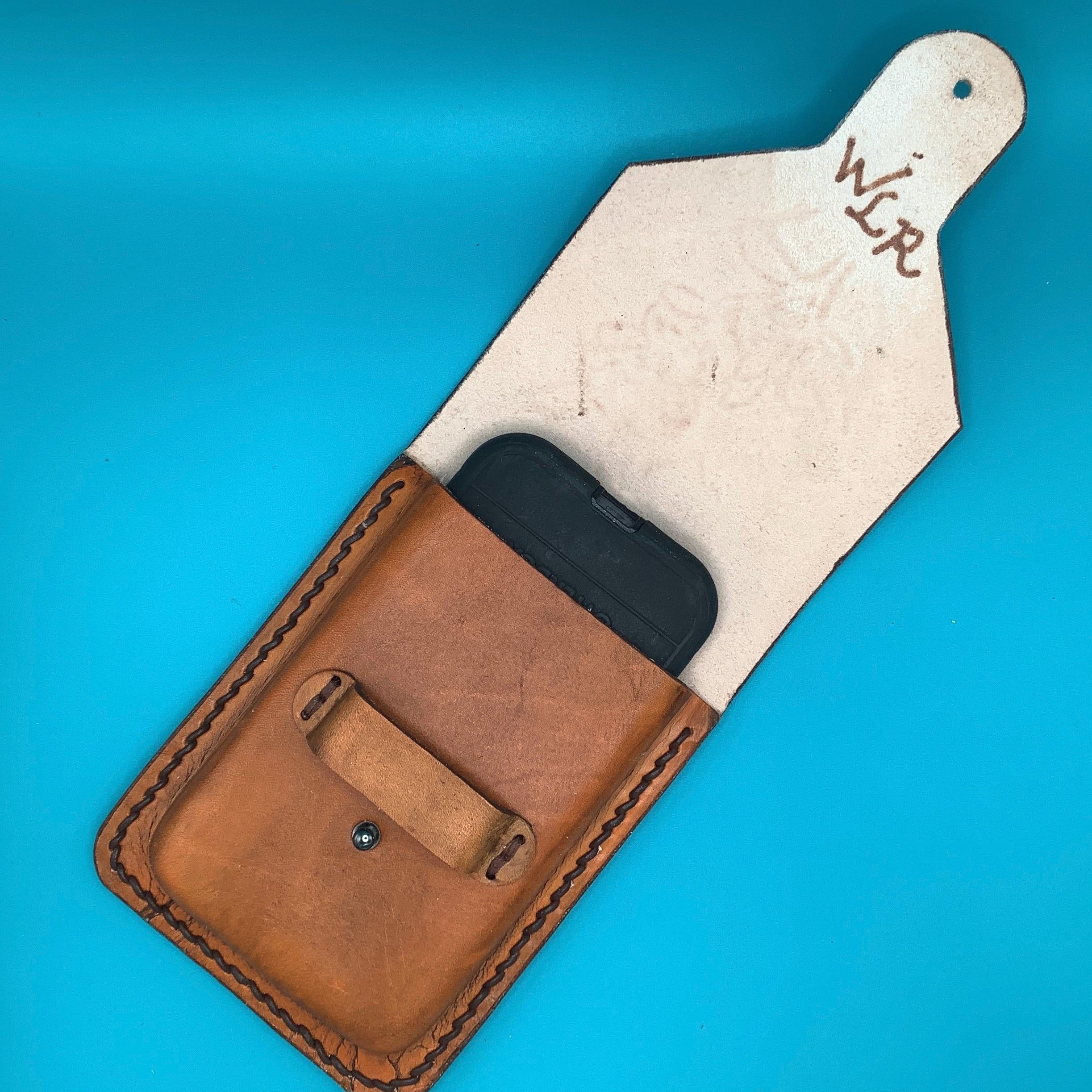 An open leather cellphone holder showing the makers mark.