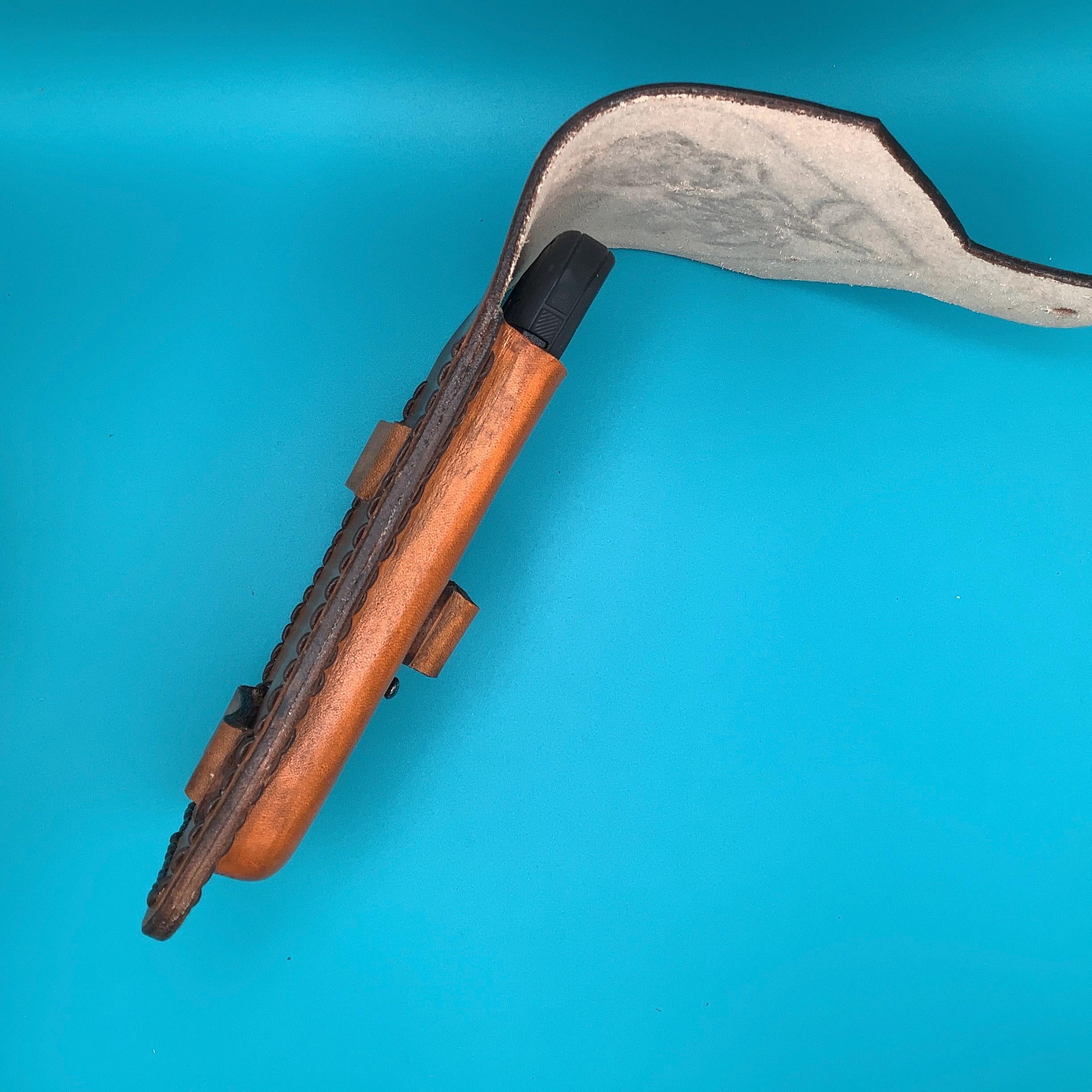 A side view of a tan leather saddle phone holder.