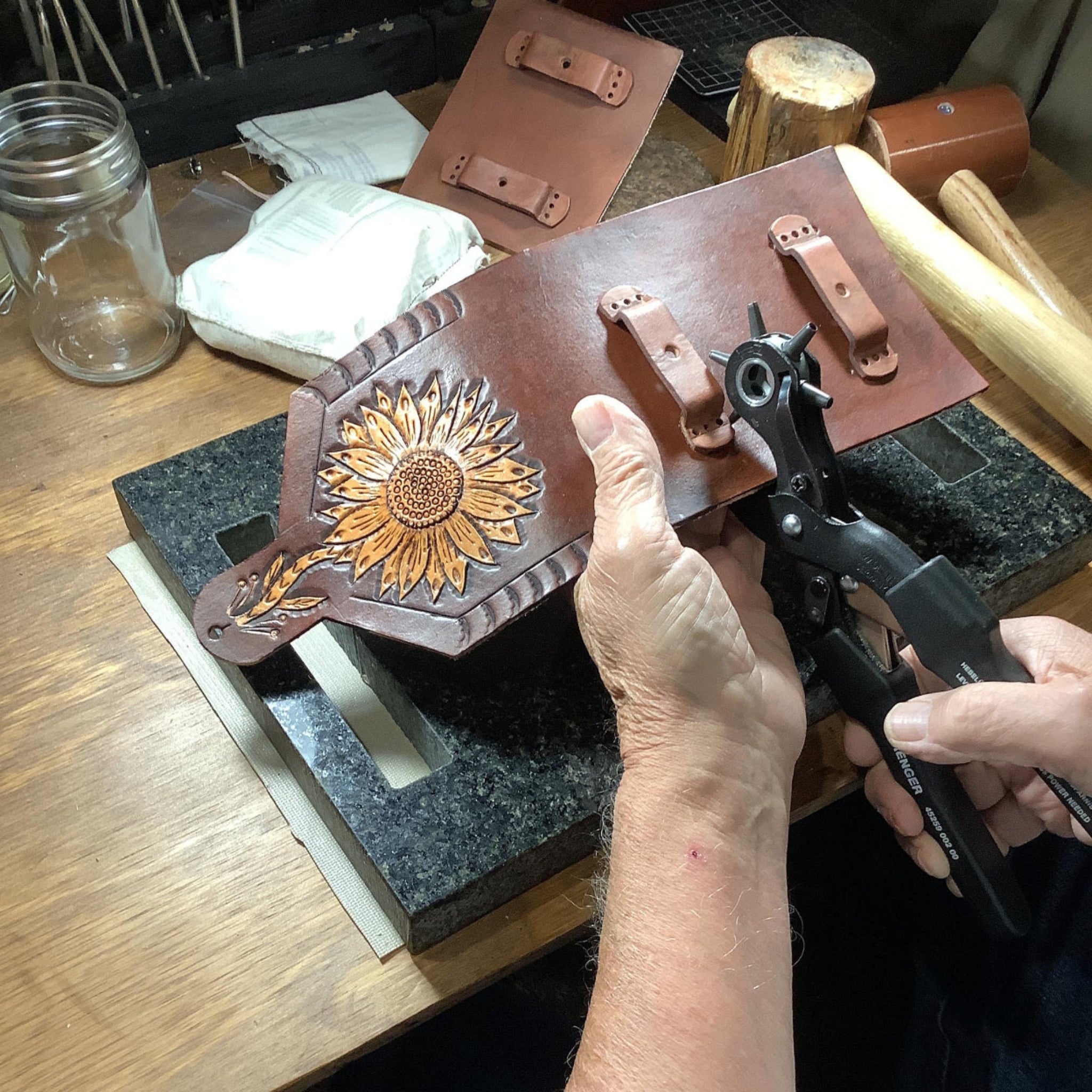 Leather worker making a saddle phone holder.