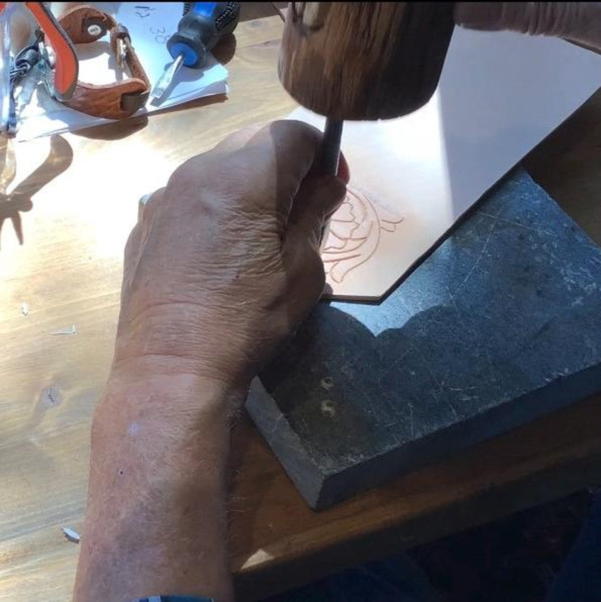 Leather worker crafting hand tooled leather.