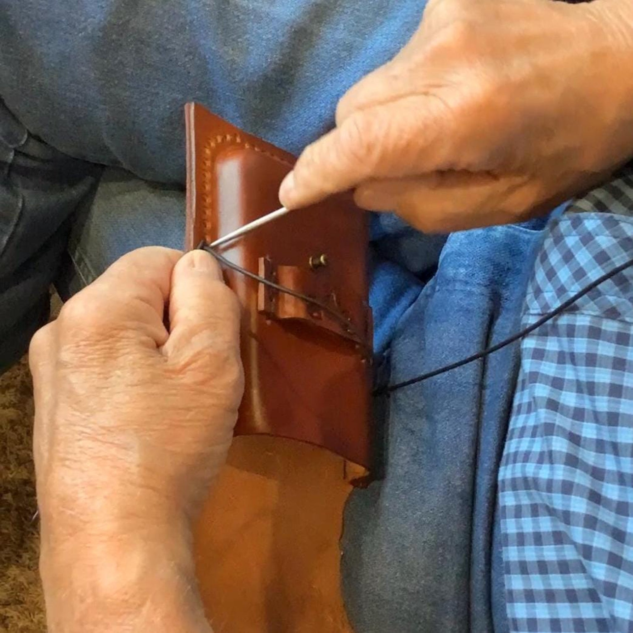 Leather worker making a saddle phone holder.