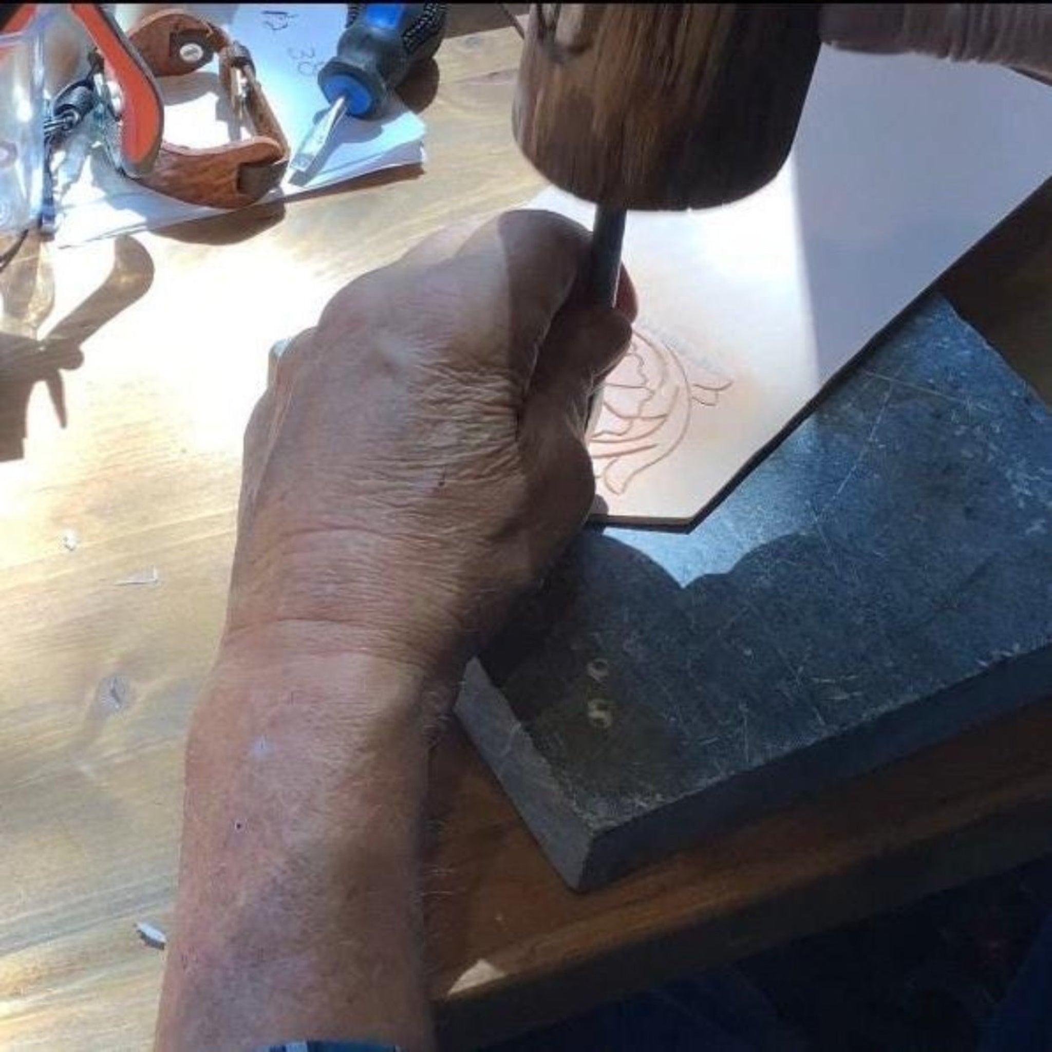 Leather worker crafting hand tooled leather.
