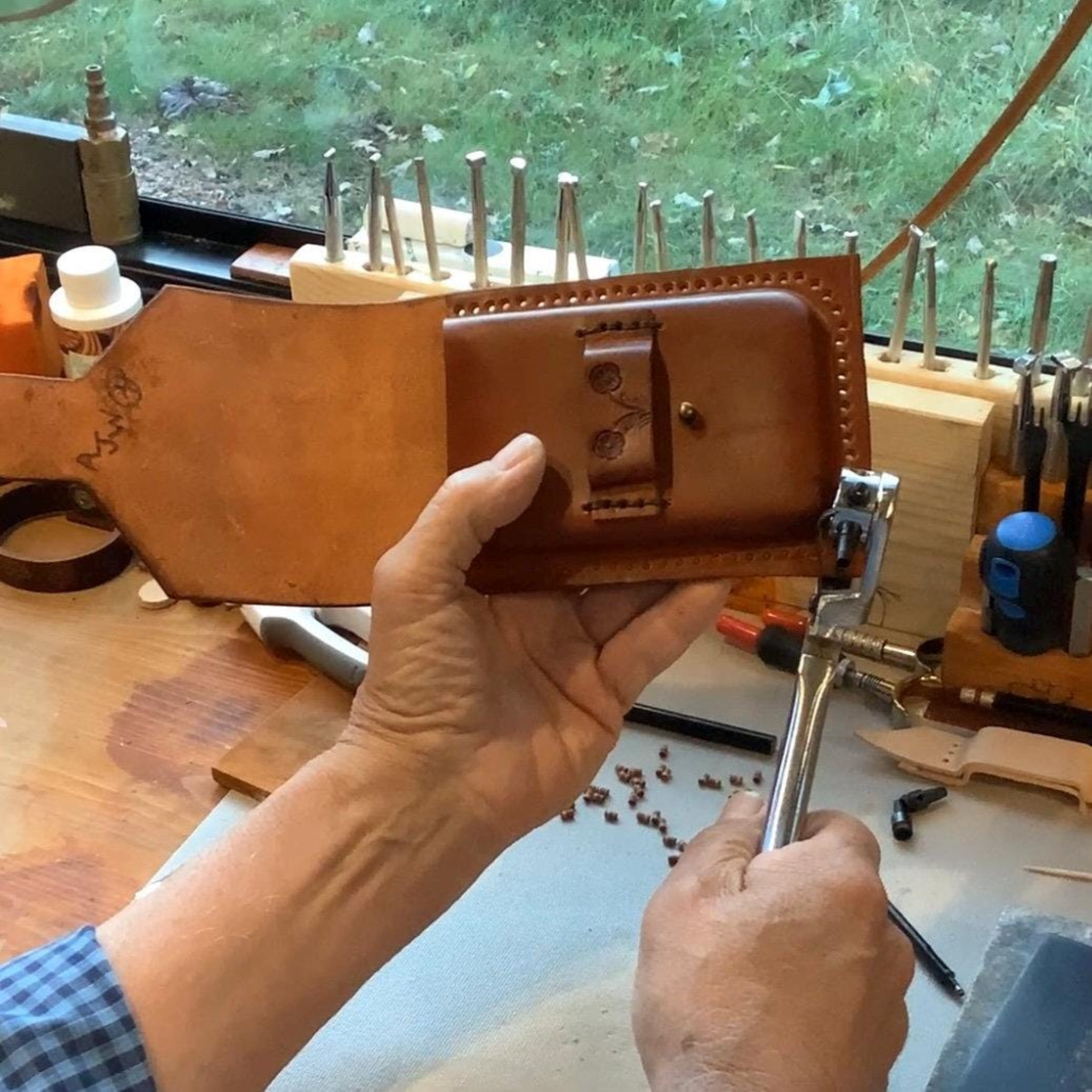 Leather worker crafting a phone holder.