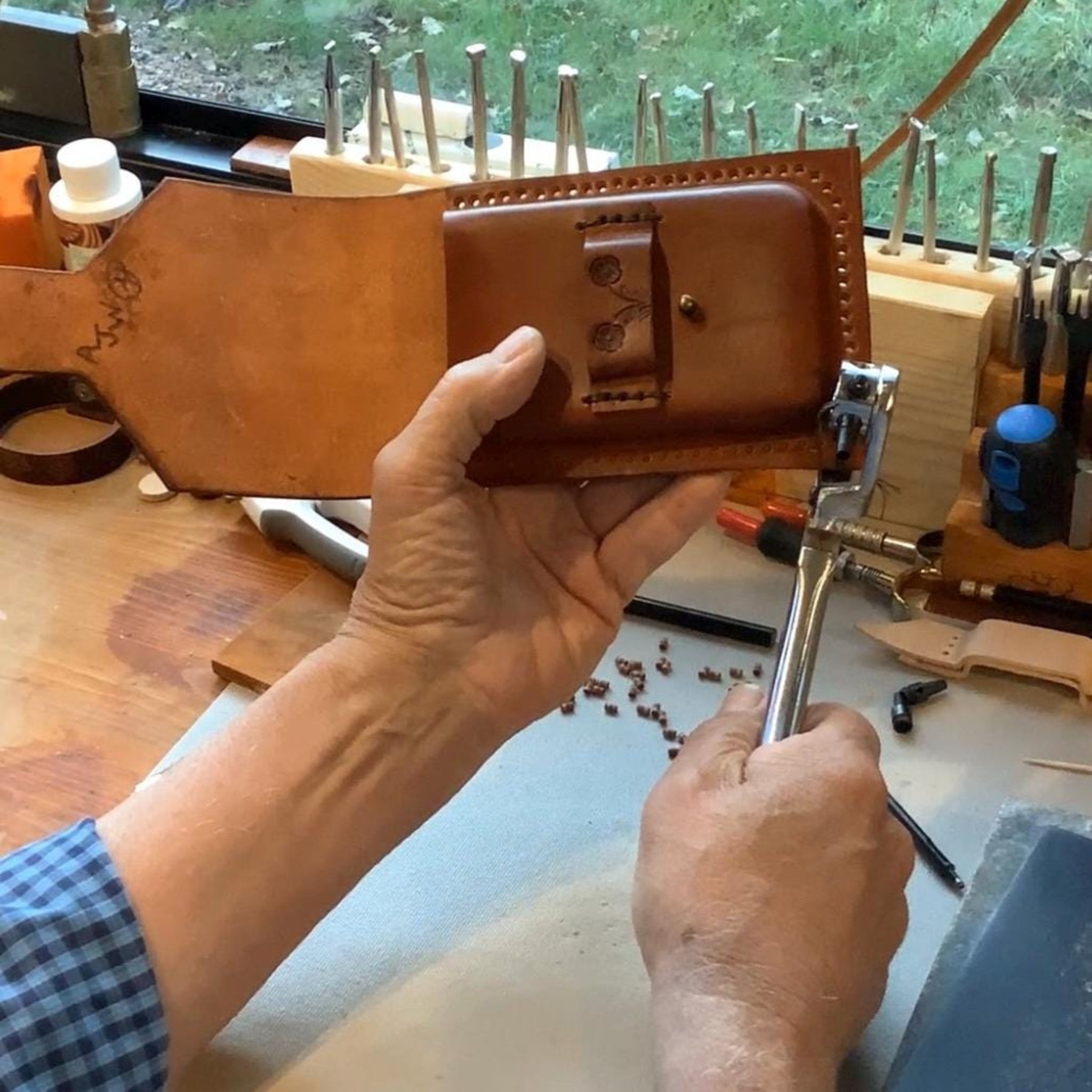 Leather worker crafting a hand tooled phone holder.  