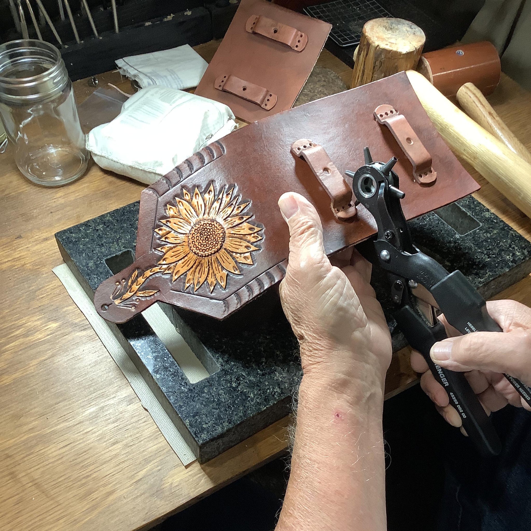 Leather worker crafting a hand tooled phone holder.
