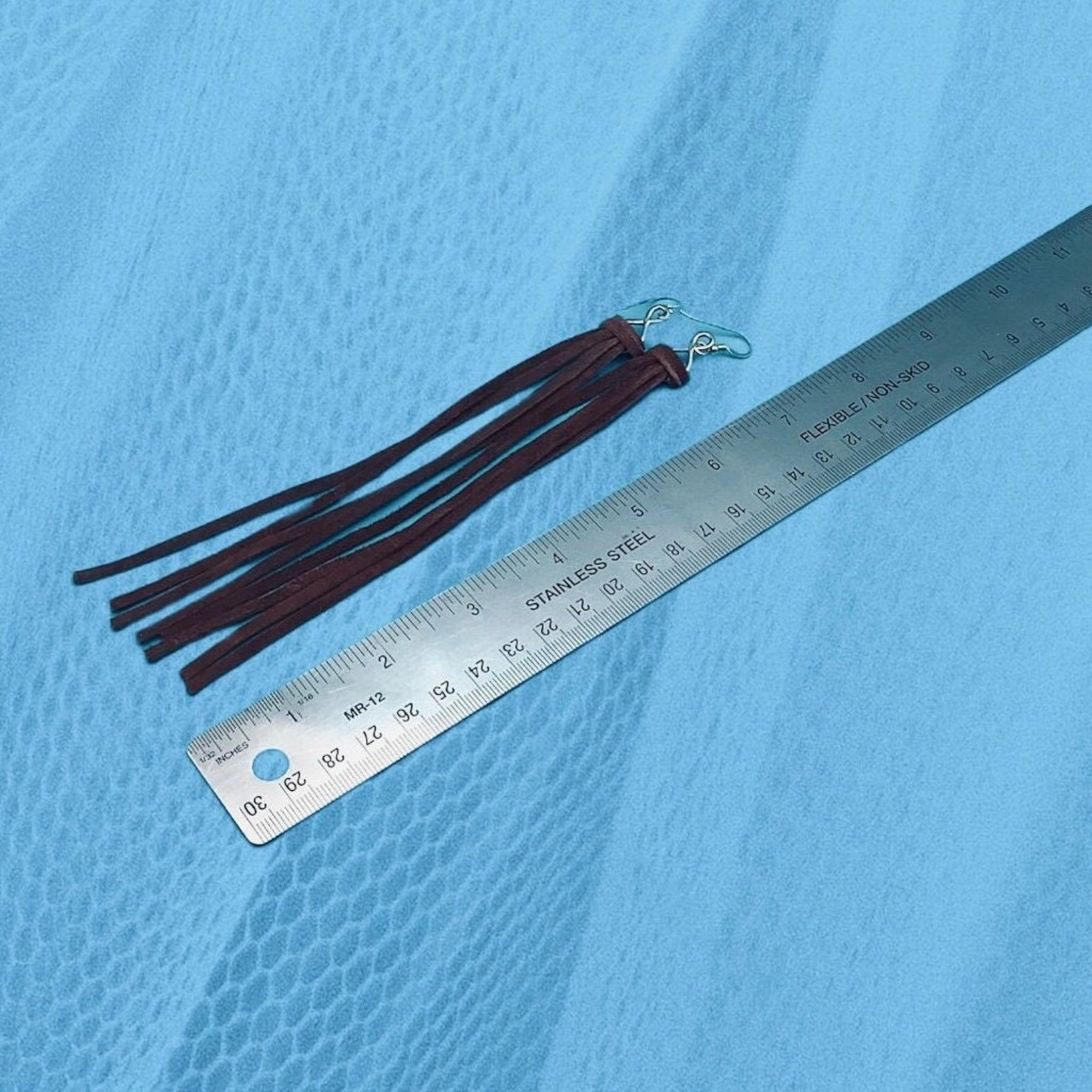 Western leather fringe earrings with a ruler showing that they measure 6" long.
