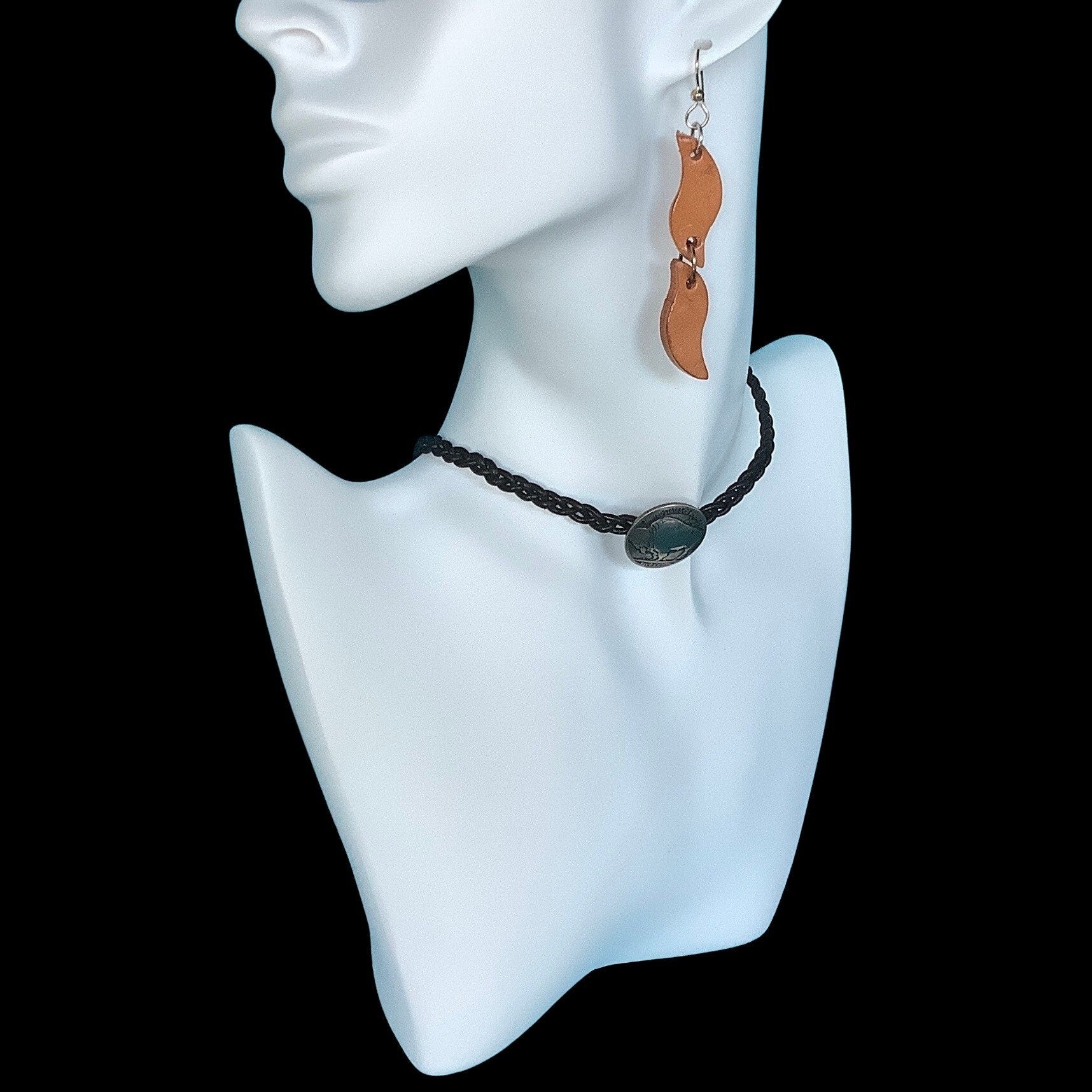 A mannequin wearing long leather earrings on sterling silver ear wires.  