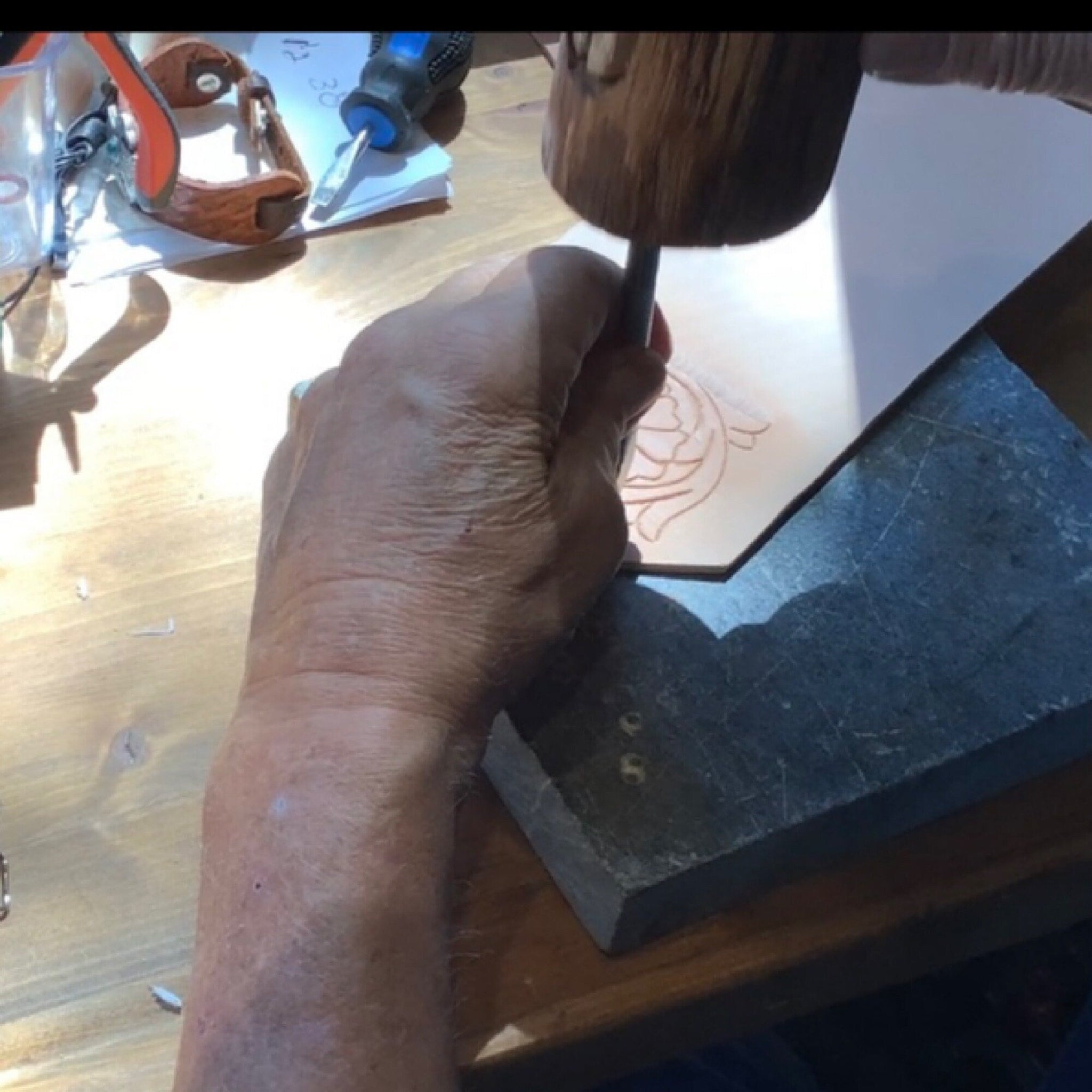 Man hand tooling leather.
