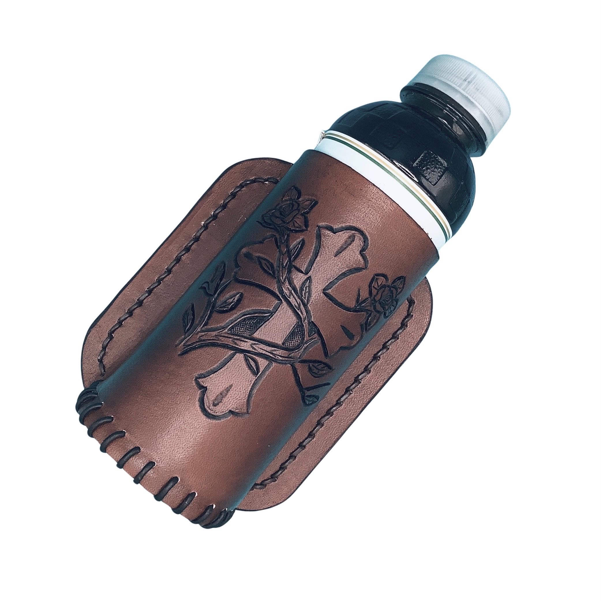 A medium brown leather bottle holder for a saddle billet with hand tooled cross and vine.