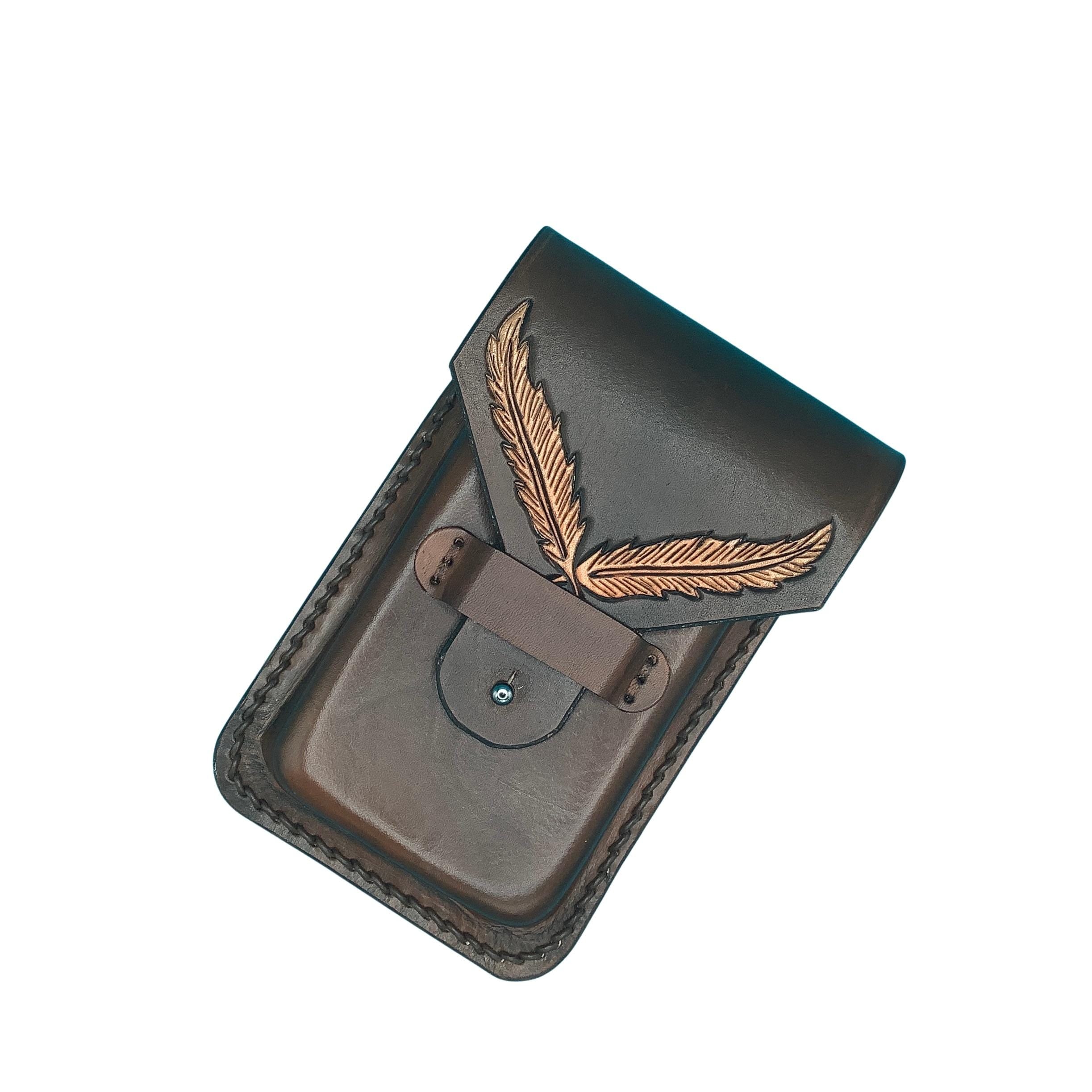 A dark brown leather phone holder for a saddle billet strap with hand tooled feathers.