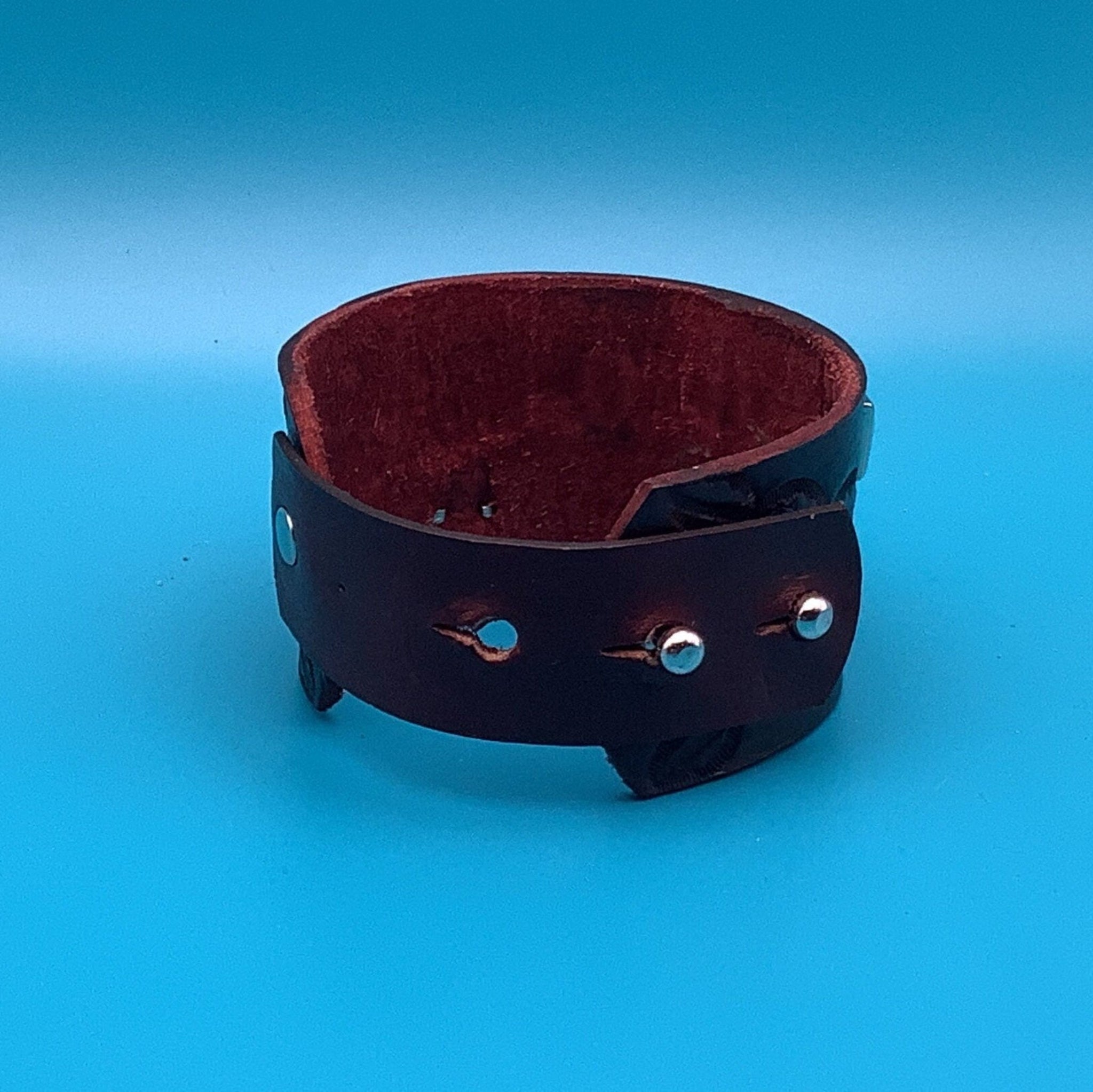 Close-up of hand-tooled leather bracelet with decorative studs